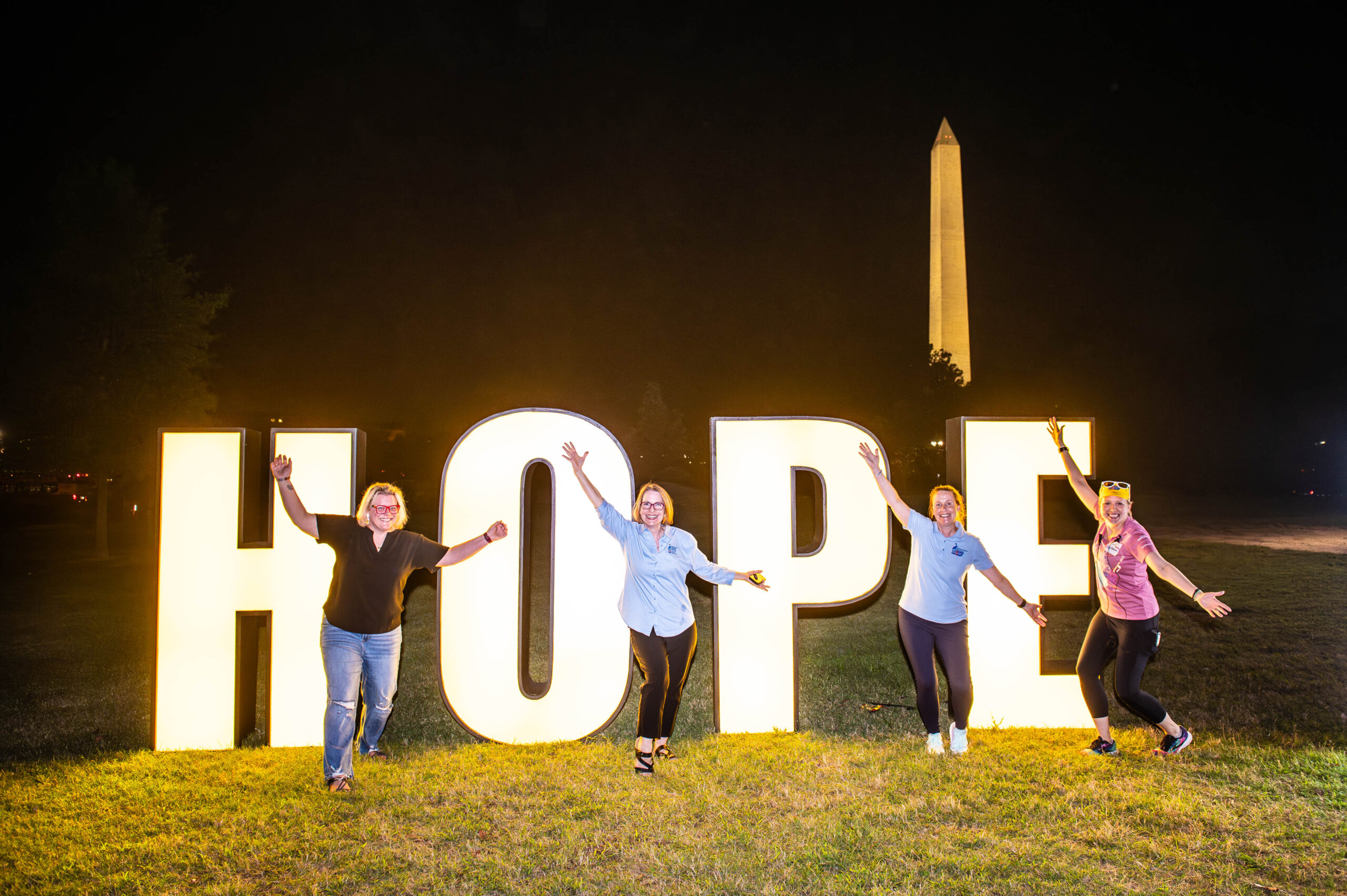 Hope sign at night with volunteers
