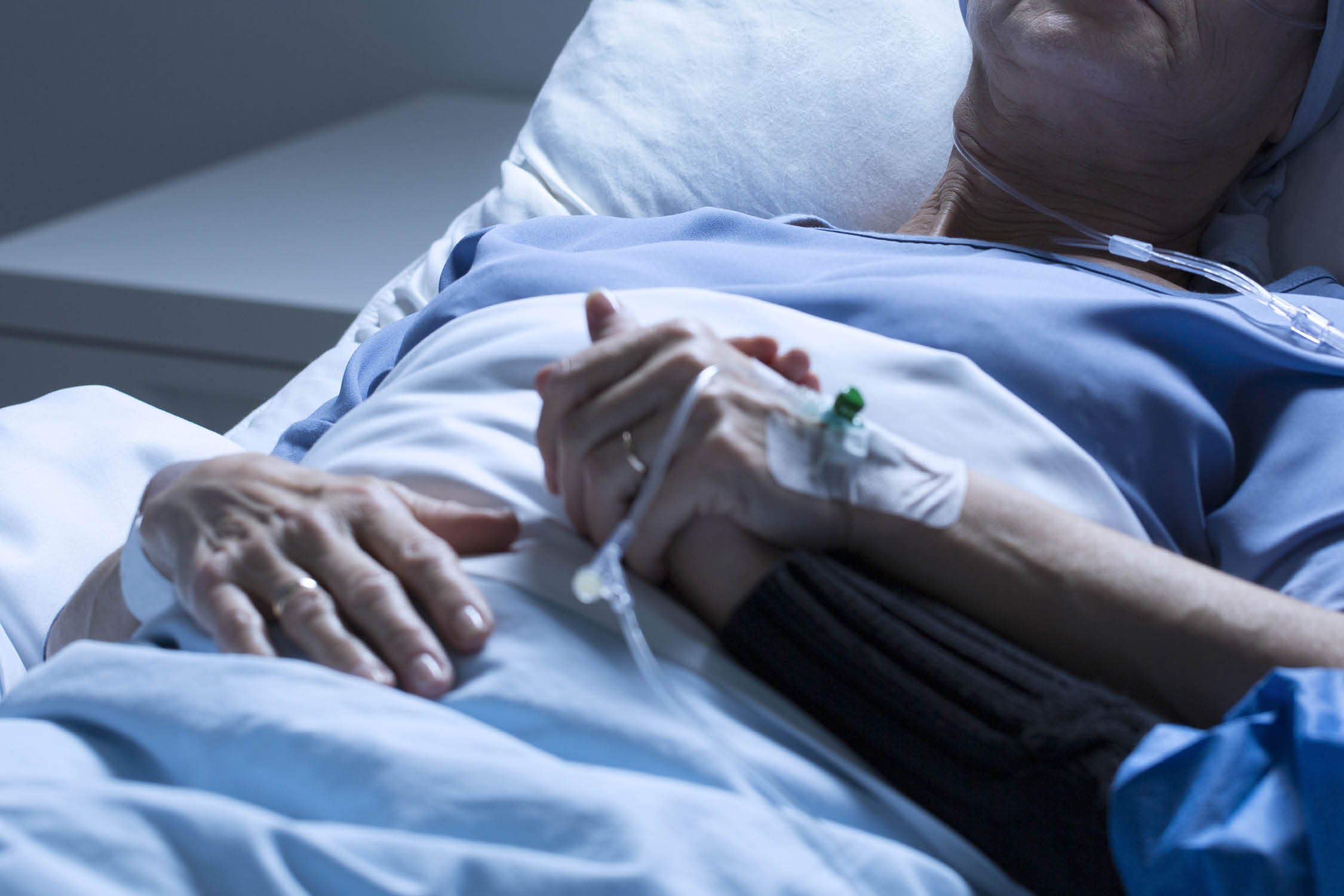 Volunteer supporting sad, dying of tumor woman in the hospital room