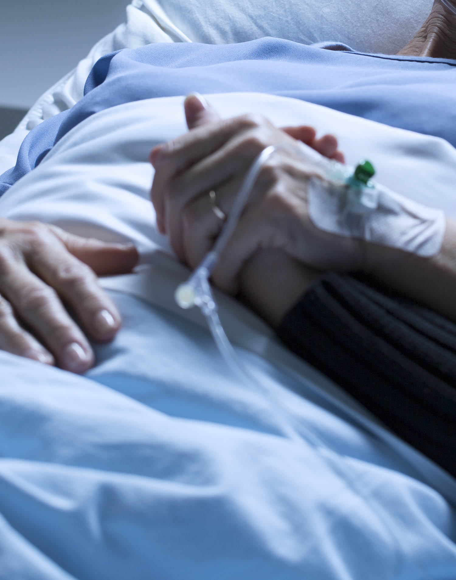 Volunteer supporting sad, dying of tumor woman in the hospital room