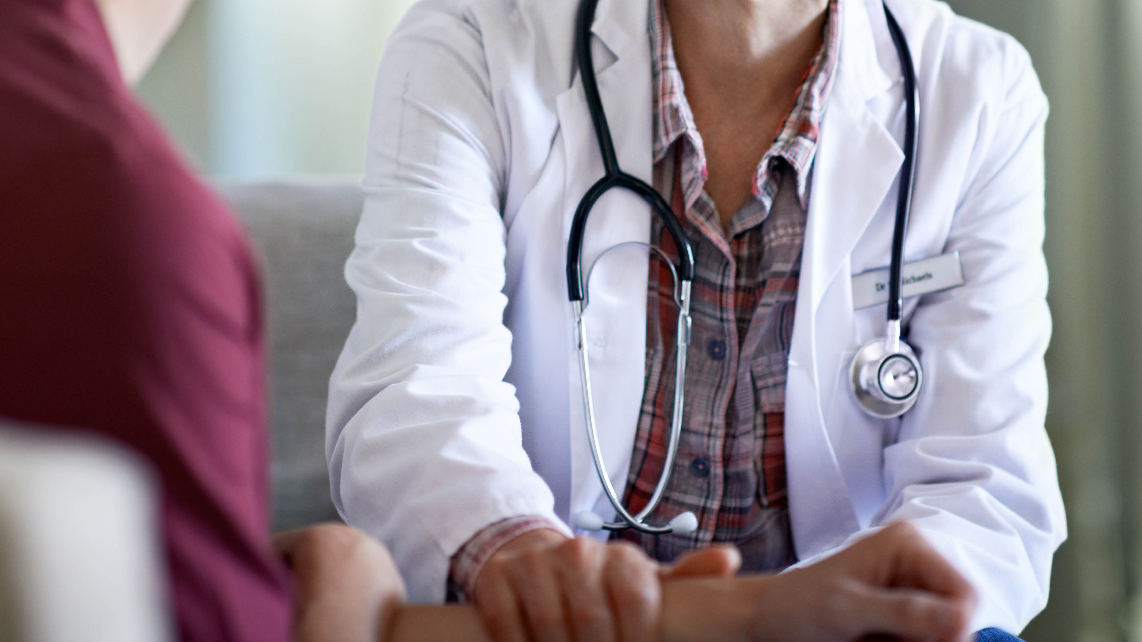 Shot of a compassionate doctor comforting a young woman in a hospital waiting room