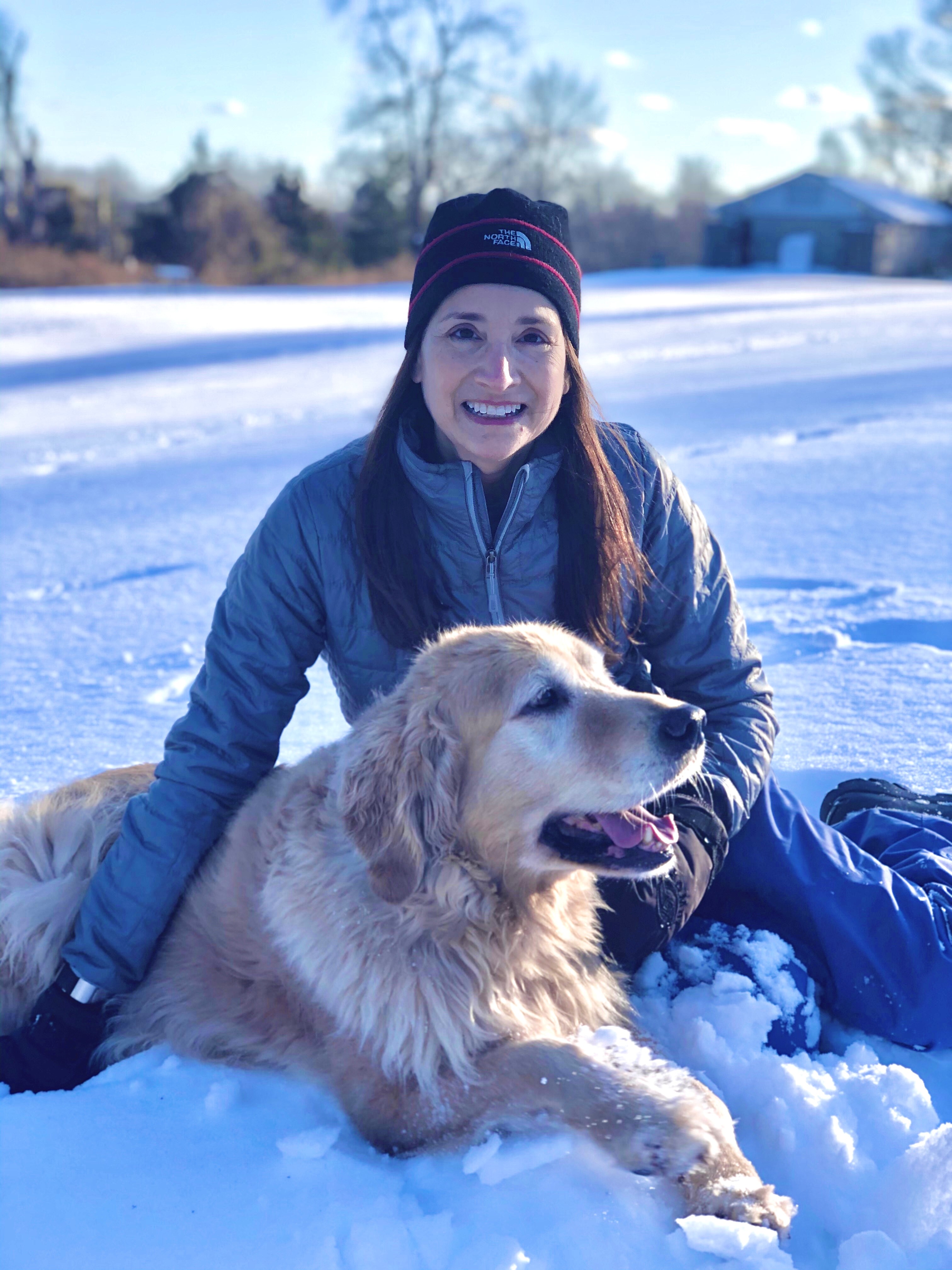 Connecticut Volunteer Linda sitting in snow with her dog