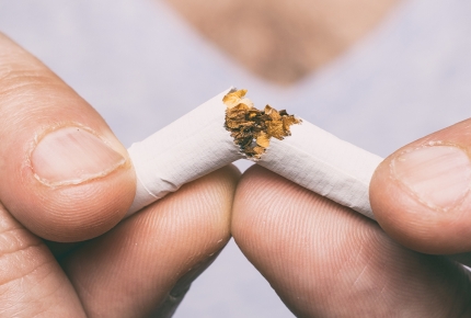 Photo of a woman breaking a cigarette in half