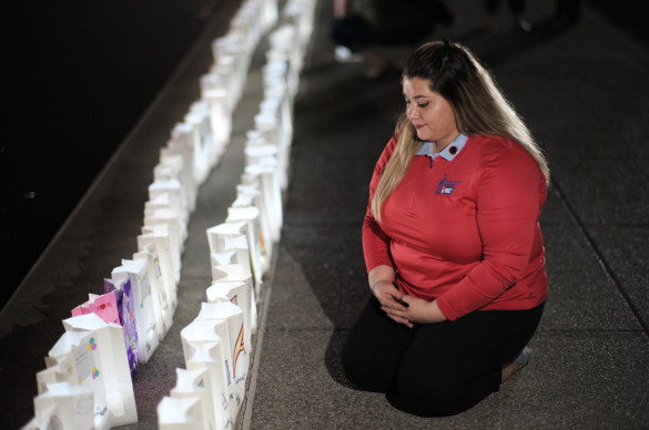 Woman kneeling by Lights of Hope bags