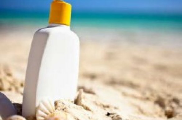 Bottle of sunscreen in sand