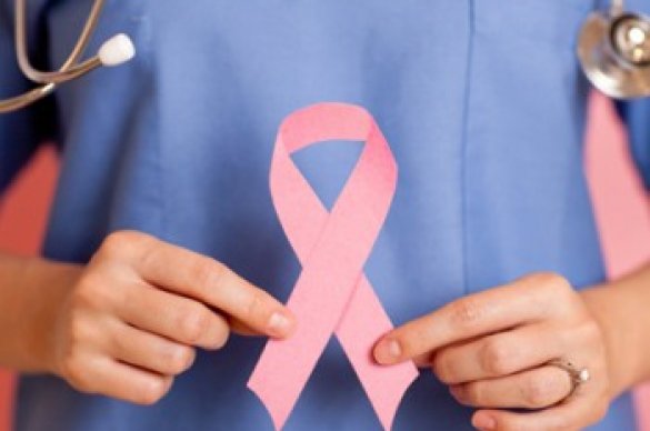 Photo of a nurse holding a pink ribbon