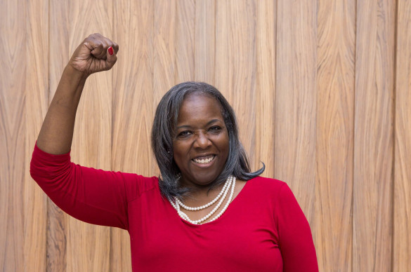 female participant raising fist and smiling at the camera