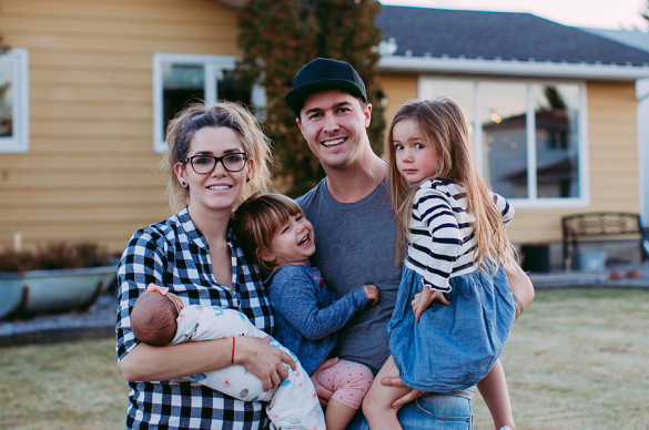 Family standing in front of their home.