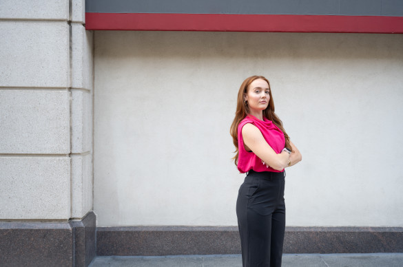 Woman in power stance looking at camera seriously