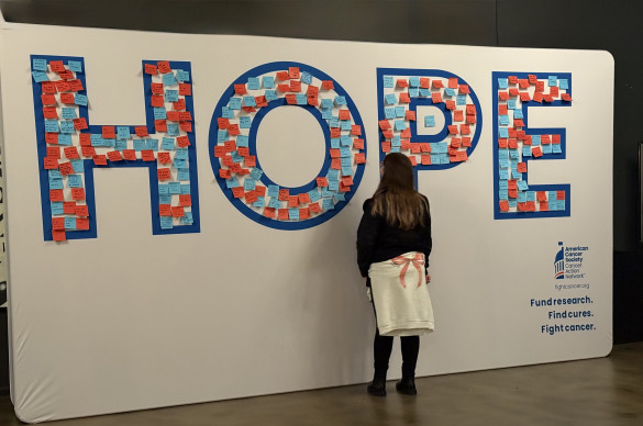 Mujer frenta a una instalación con la palabra 'HOPE', que significa esperanza