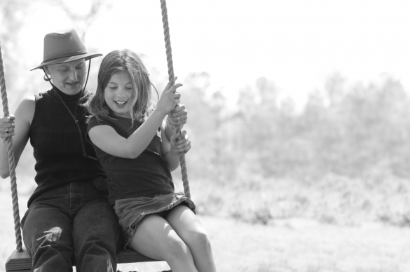 cancer survivor and daughter on a wooden swing