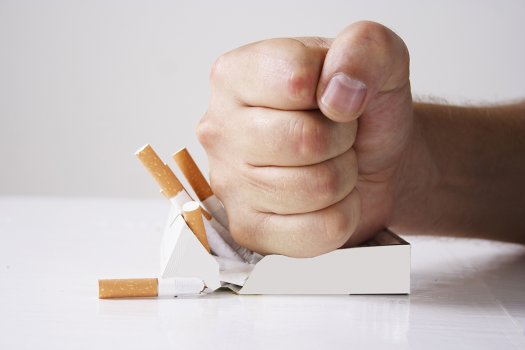 Hand crushing a pack of cigarettes Hand crushing a pack of cigarettes