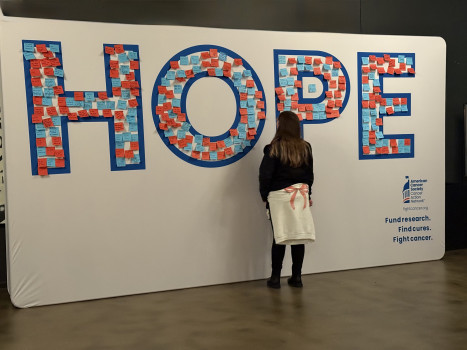 Mujer frenta a una instalación con la palabra 'HOPE', que significa esperanza