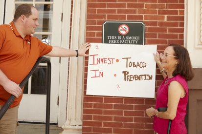 volunteers hold up anti-smoking sign