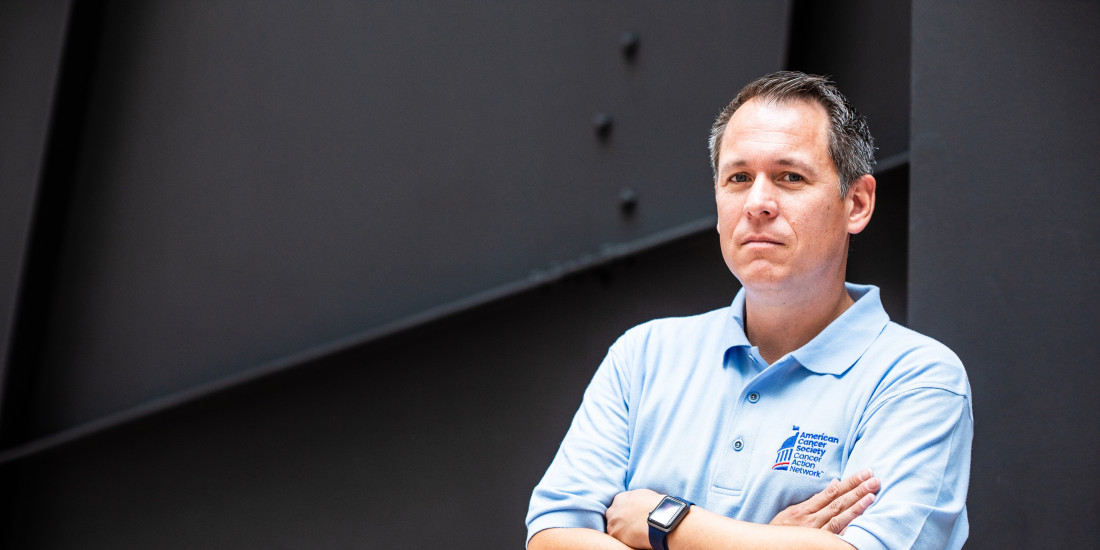 Man with arms crossed, serious expression and wearing an ACS CAN polo