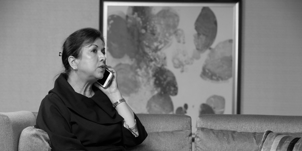 woman on phone with serious expression, left aligned 