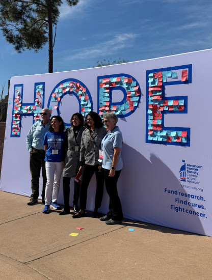 Volunteers stand in front of HOPE wall