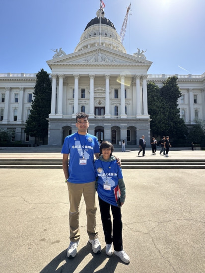 Two young advocates stand in front of the California State Capitol