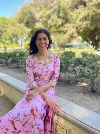 ACS CAN volunteer Punita Khanna sits in front of a garden.