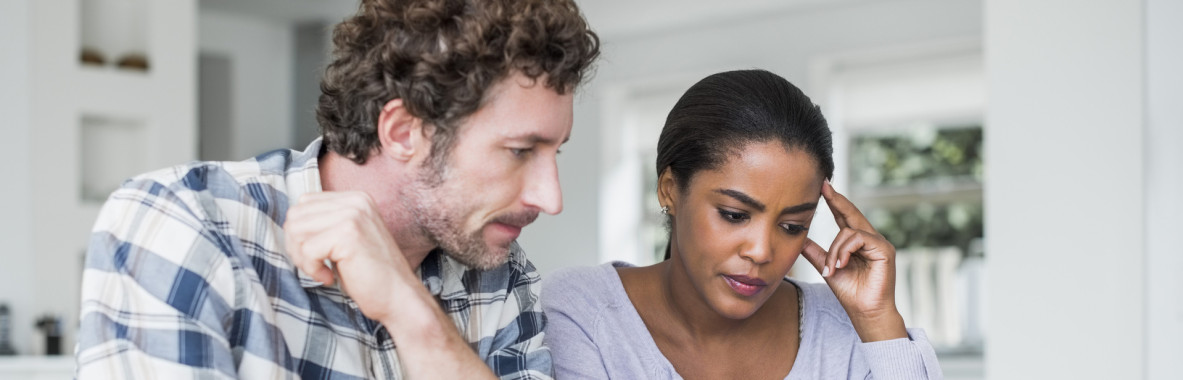 Tensed couple reading bills
