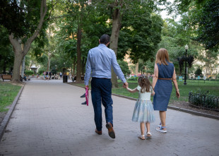 Family walking in the park A man, woman, and child walking through a park holding hands