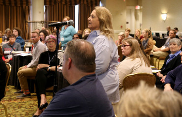 volunteer speaking at a microphone during a training session