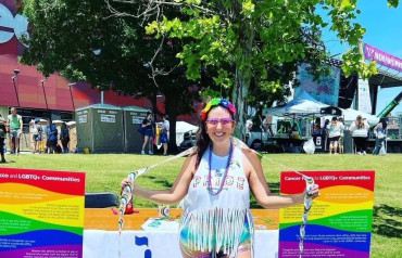 LGBTQIA+ volunteer in front of ACS CAN outdoor booth